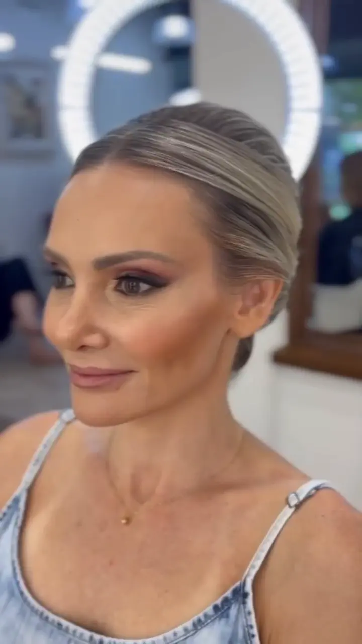 Cliente com maquiagem pronta e penteado preso