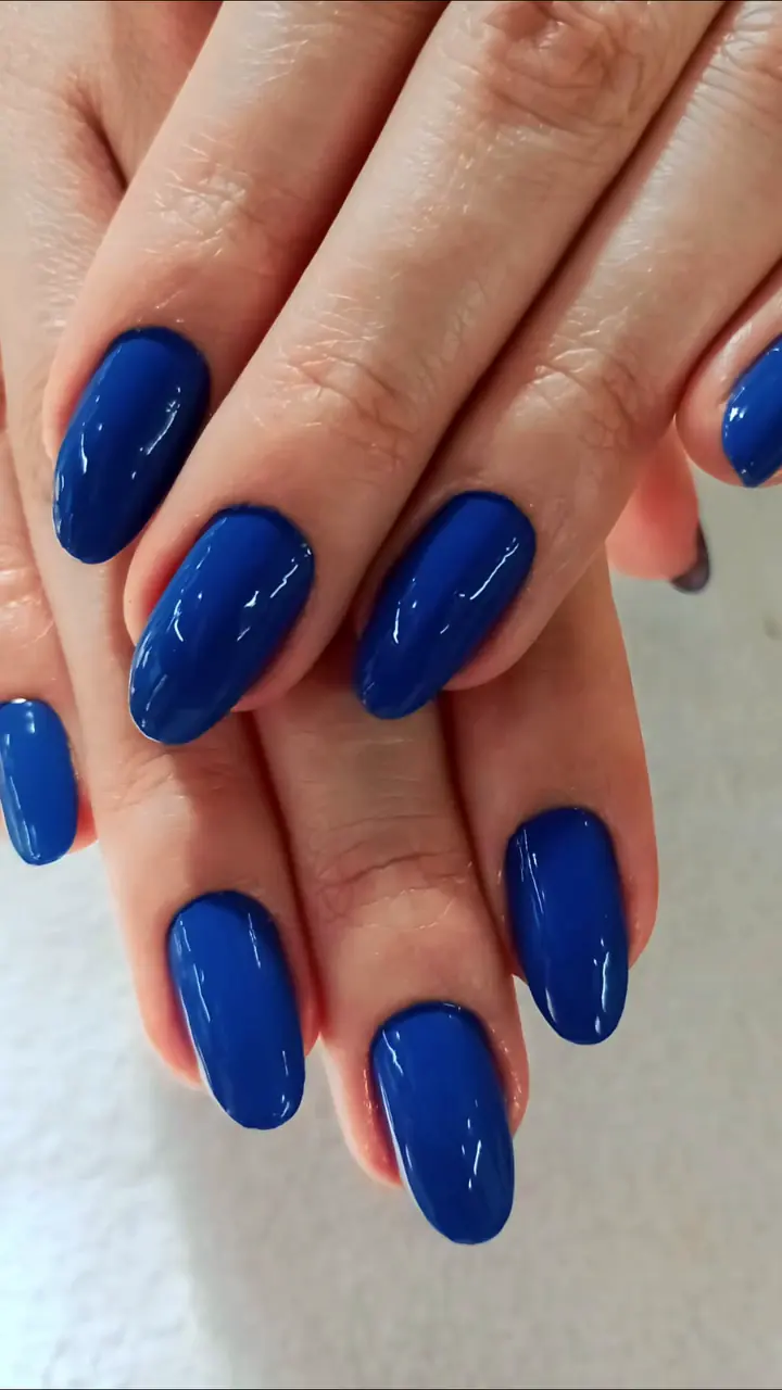 Mão com unhas longas esmaltadas de azul royal